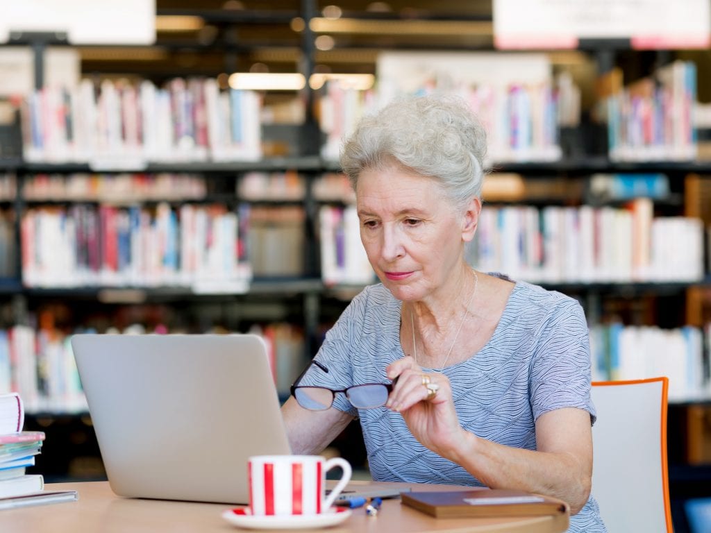 older woman reading off her computer