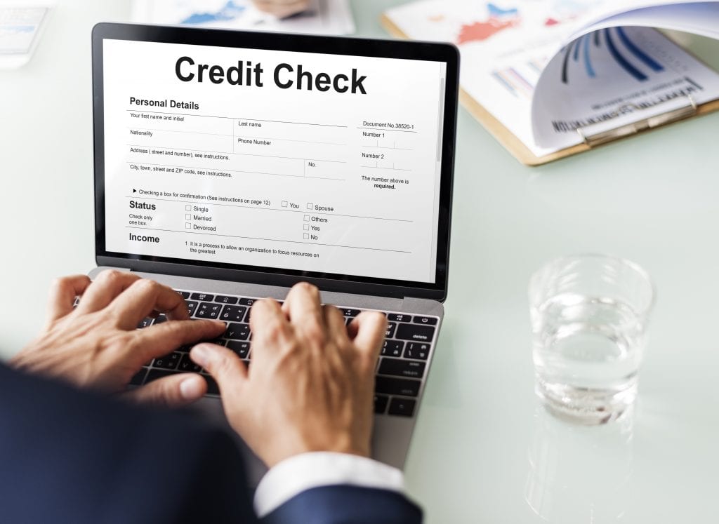 man types on computer about credit check